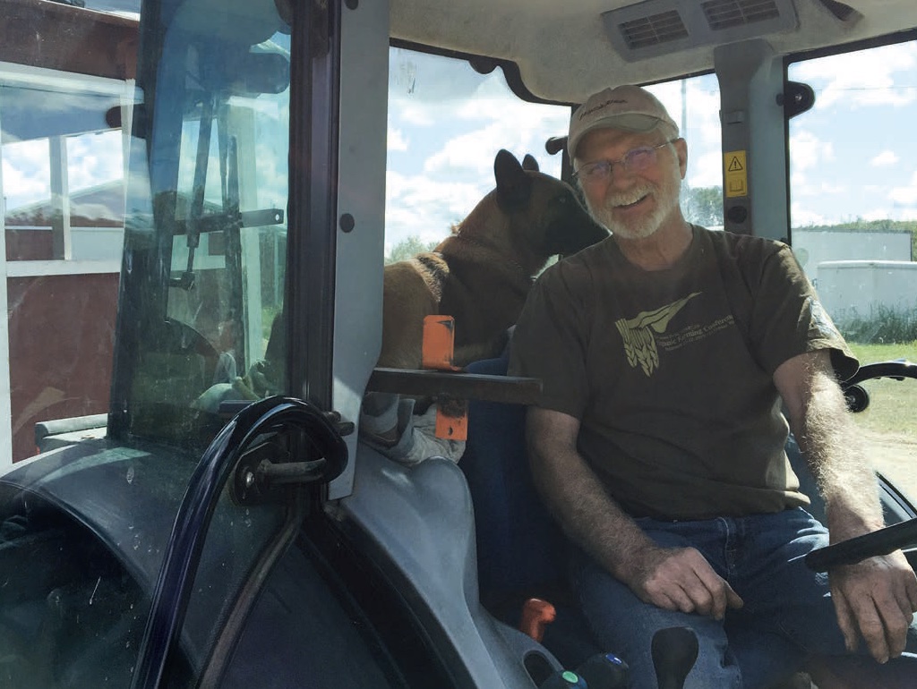  Jim Koan with Kahlua the dog. She is a Belgian Malinois and has her own personal seat in the tractor with him.