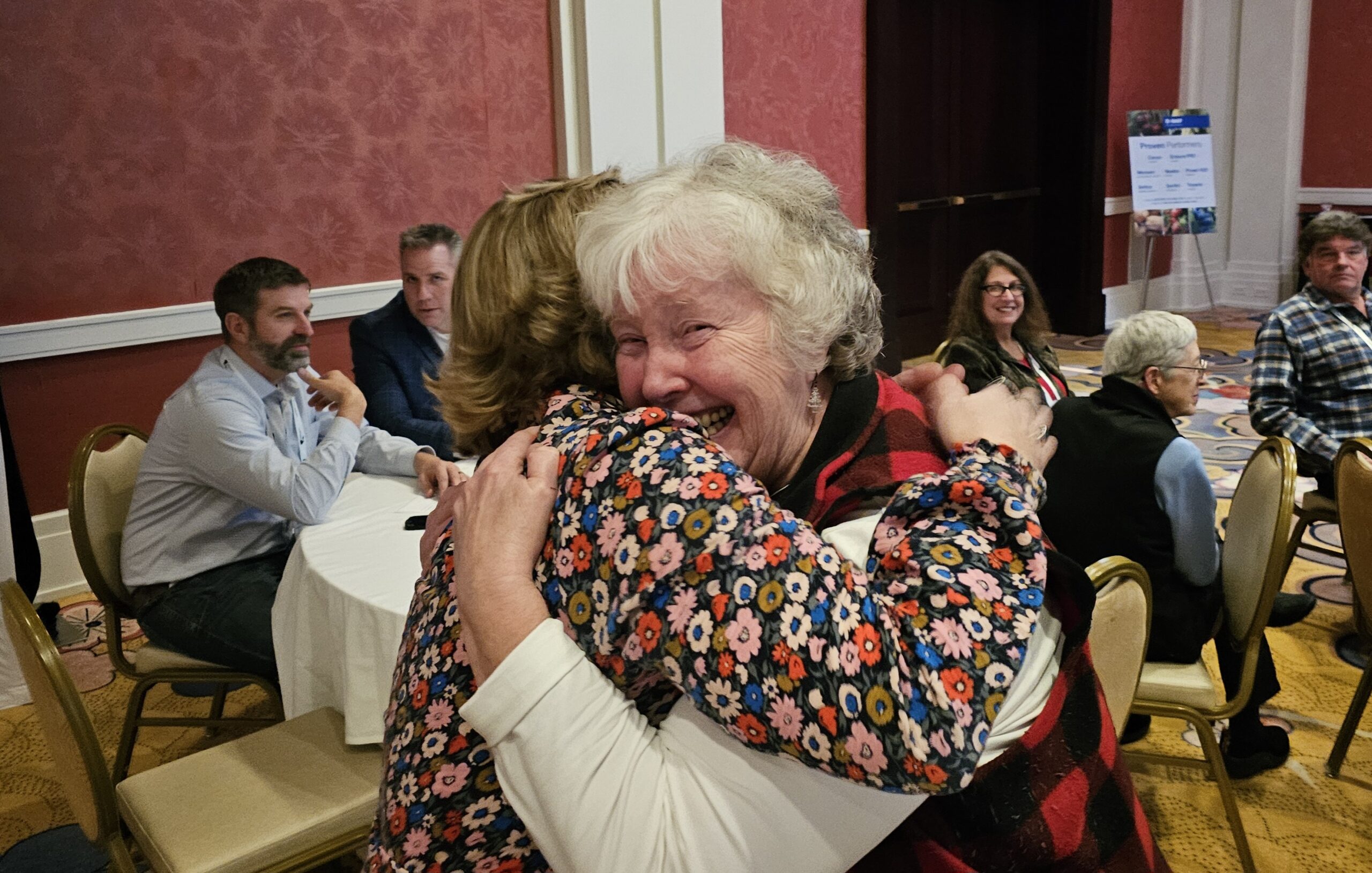 Two women hugging and smiling at the camera.