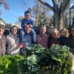 Good Humus Produce’s family members in front of leafy greens.
