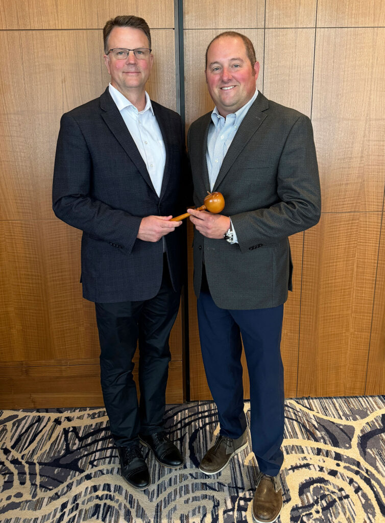 Steve Clement, from left, passes the gavel of the leadership of USApple's board of directors to Brett Baker. Baker became chair at USApple’s Aug. 14-16 Chicago Outlook conference.